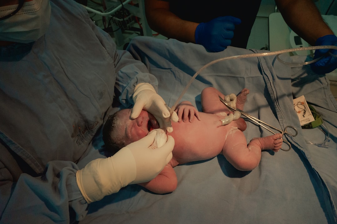 Newborn baby being attended to by medical professionals.