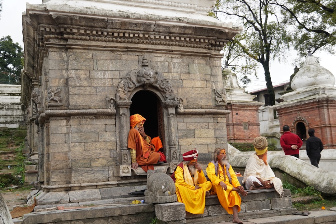 Sadhus sit outside stone temple structures