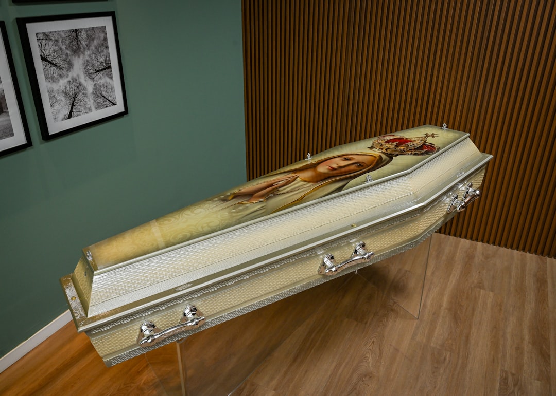 A white casket sitting on top of a hard wood floor