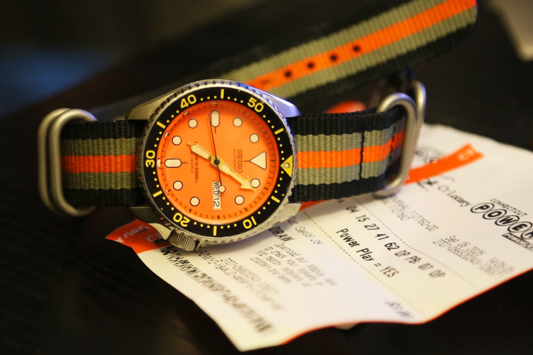 Orange faced watch with striped nato strap